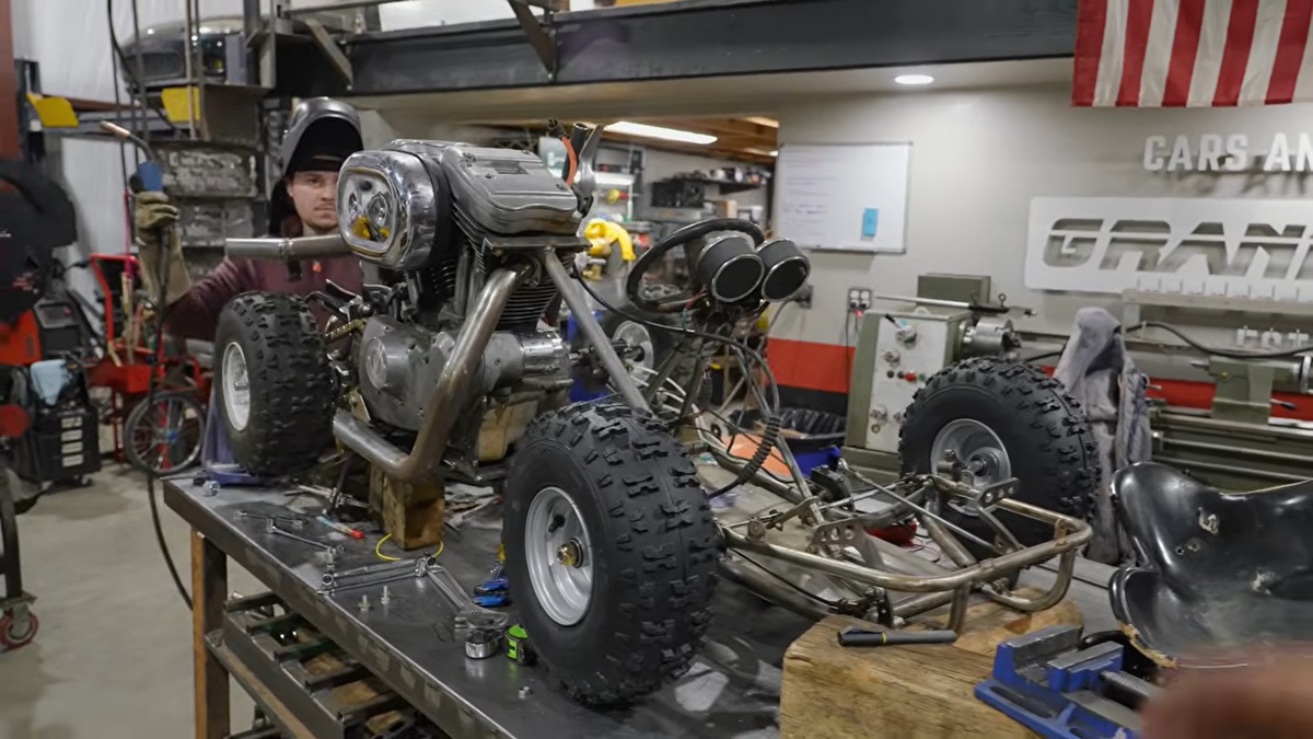 A custom go-kart with knobby tires and a Harley-Davidson engine